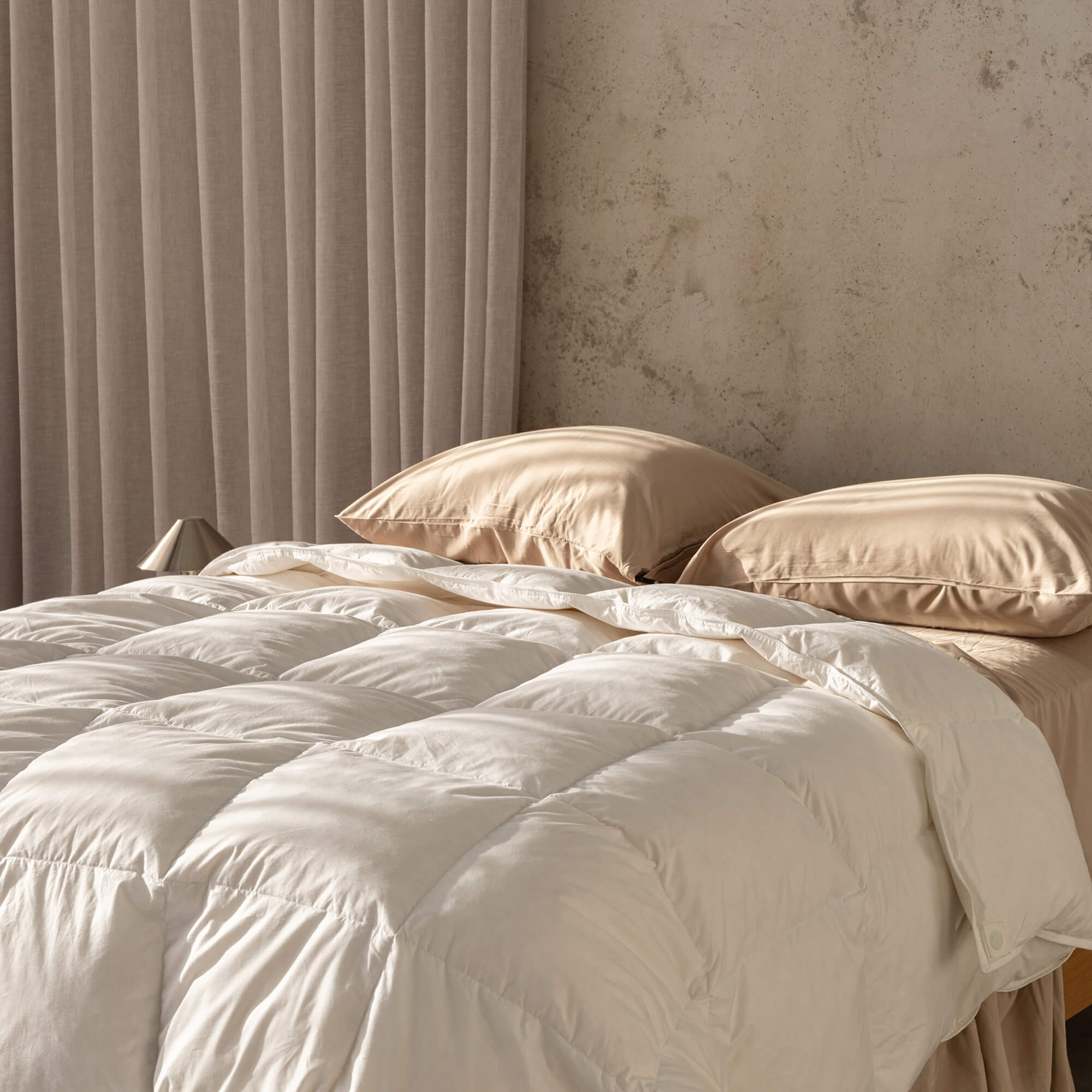 Doona without cover on it and creme coloured sheets 