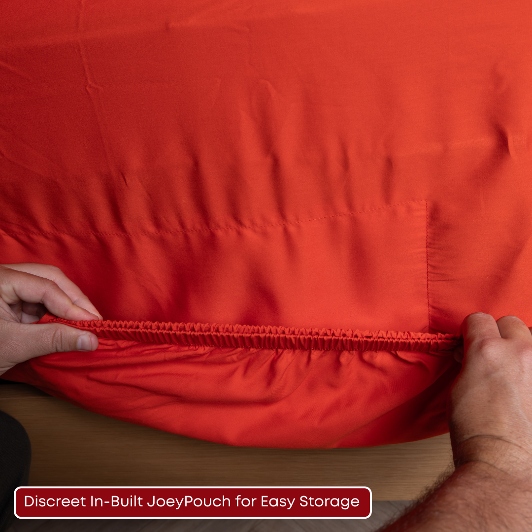Stretchy fit of red bamboo cotton fitted sheet being pulled to showcase the JoeyPouch.