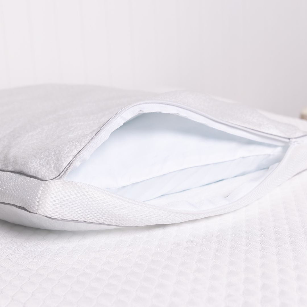 Close-up of a white pillow with a clear plastic cover on a light gray background