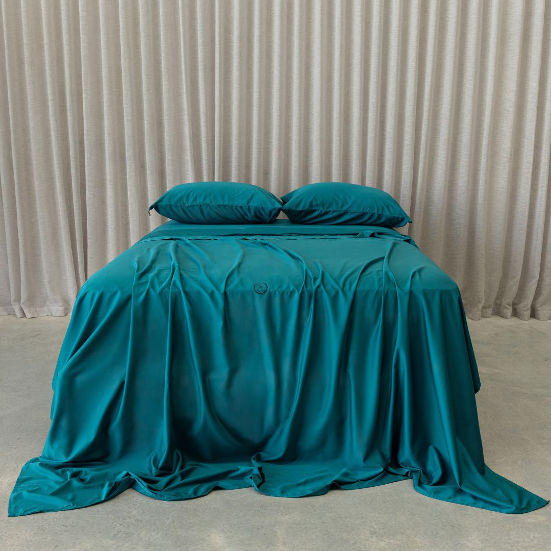 Teal bed sheets with curtain background 