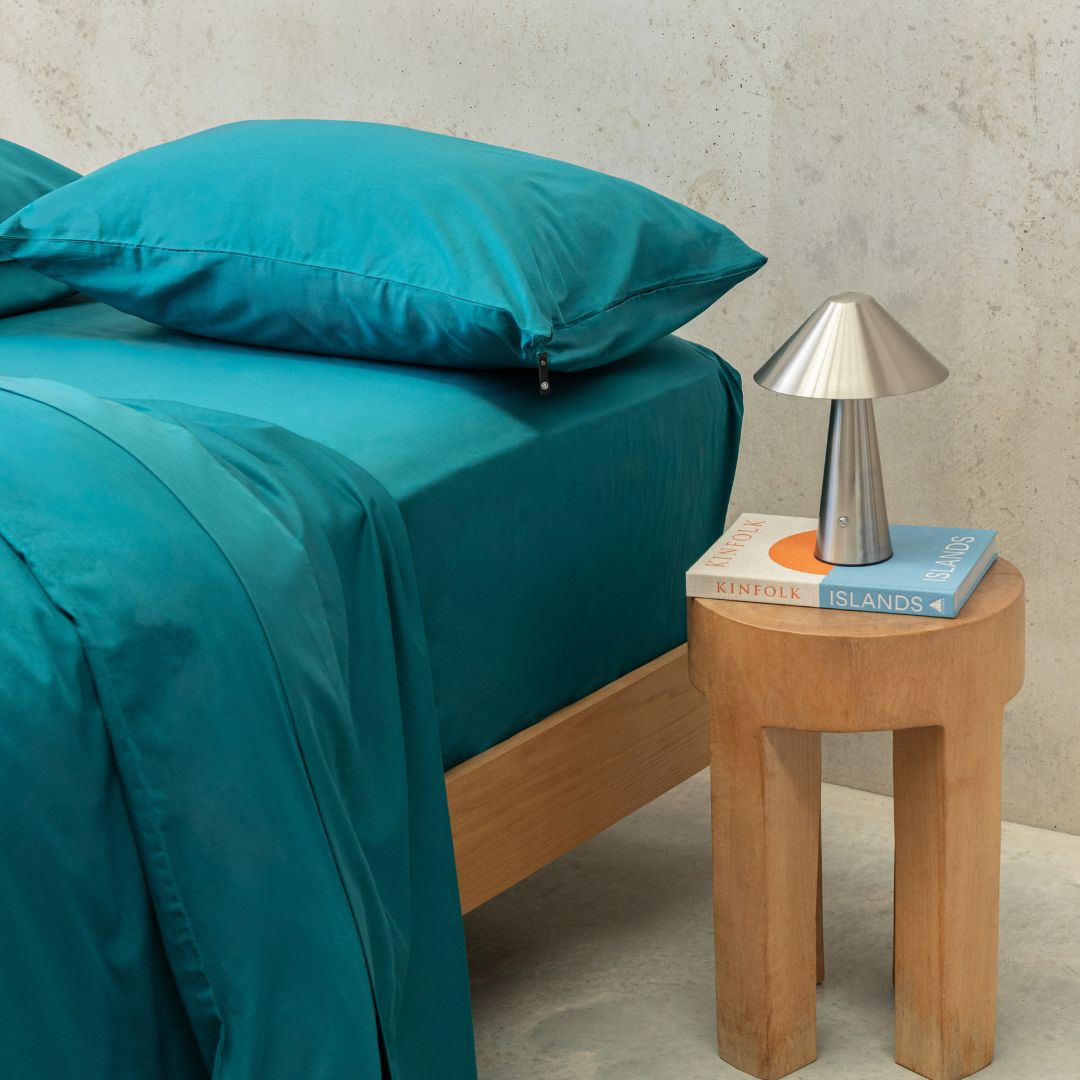 Teal bed sheets with stone background 