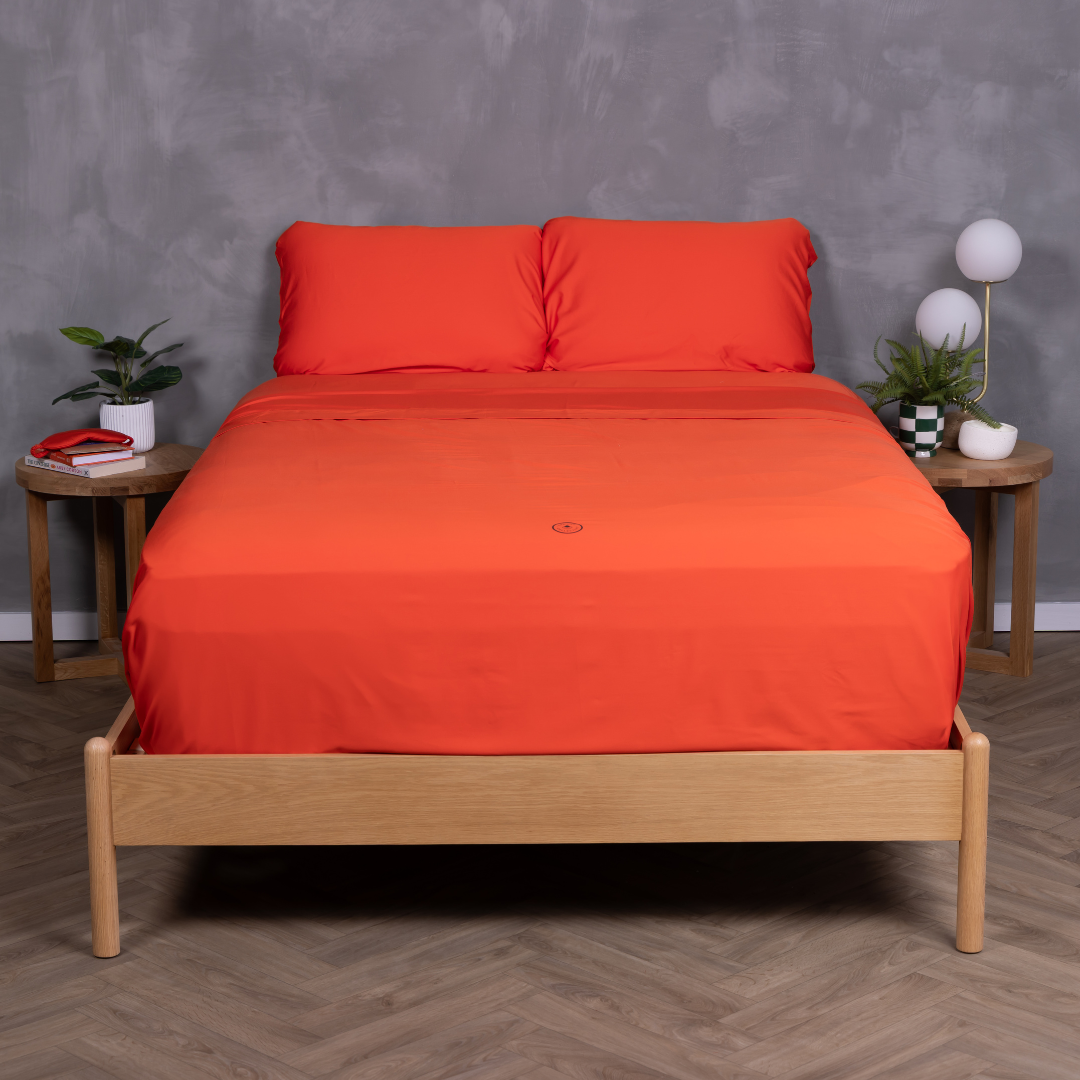 Modern bedroom with queen bed made with red bamboo cotton sheet set and matching pillows.