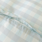 Close-up of a light blue gingham quilt cover featuring a concealed zipper closure, showcasing the secure fastening detail and soft woven fabric texture