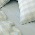 Light blue gingham quilt cover and pillowcases paired with a matching blue fitted sheet, showcasing the soft fabric texture and coordinated bedding design.