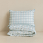 Folded light blue gingham quilt cover set with a matching pillowcase stacked neatly, highlighting the classic check pattern and soft, breathable fabric.