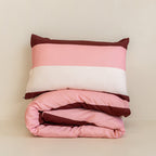 Folded striped quilt cover set with a matching pillowcase in blush pink, cream, and burgundy tones, neatly stacked to showcase the bold stripe pattern and soft fabric.