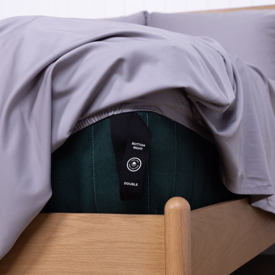 The bottom right labelled loop corner strap showing on the Margaret River fitted sheet, on a double bed. 