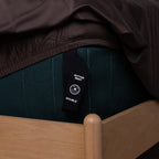 Chocolate brown fitted sheet with a labeled corner strap to show which corner goes where.