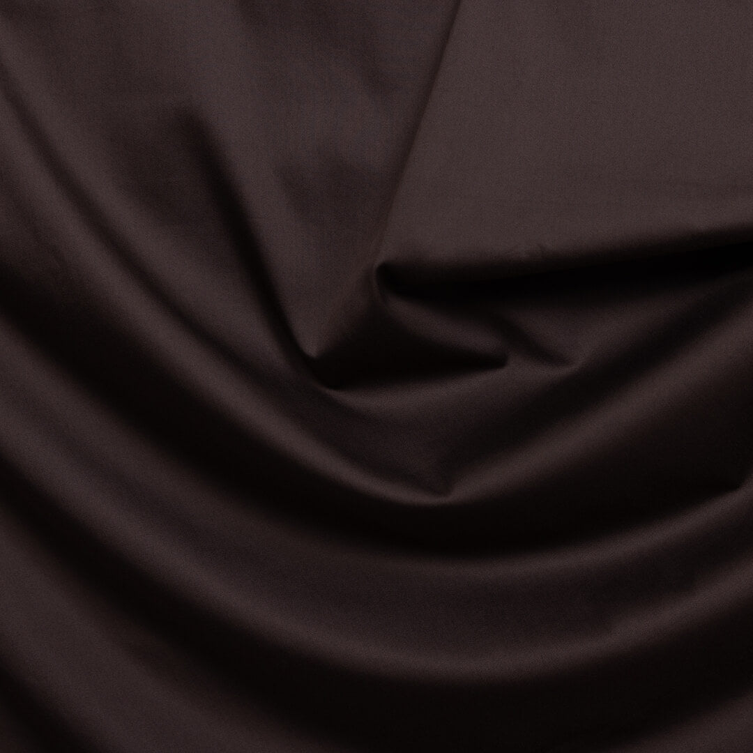 Chocolate brown fabric material with folds.