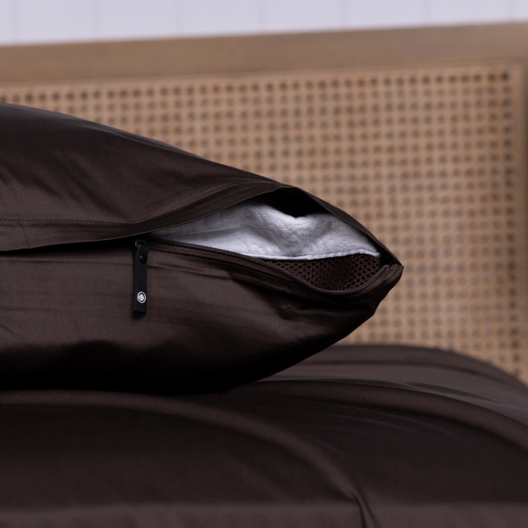 Chocolate brown invisible zip pillowcase shown slightly unzipped on a pillow.