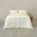 Cream quilt cover set featuring a delicate yellow floral motif made up on a double bed with two matching pillowcases