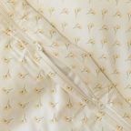 Close-up detail of a cream floral print quilt cover with an open zipper closure