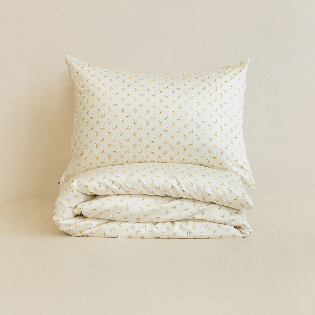 Neatly folded cream floral print quilt cover with one matching pillowcase resting on top