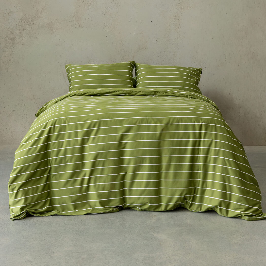 Green striped bedding set on a bed against a plain wall.