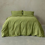 Green striped bedding set on a bed against a plain wall.