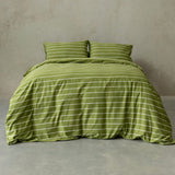 Green striped bedding set on a bed against a plain wall.