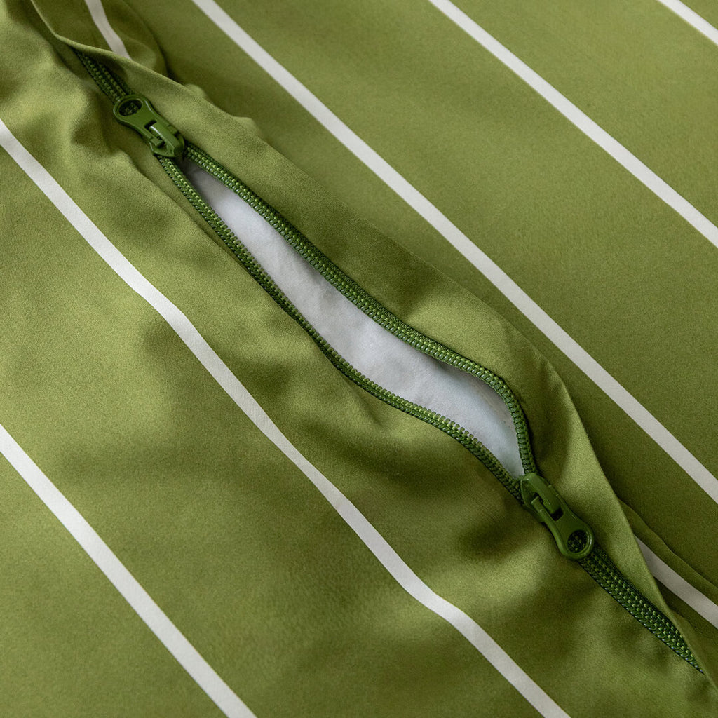 Close-up of a green quilt cover with a zipper on a green background.