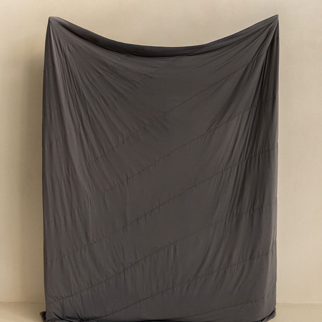 Charcoal coloured cooling blanket held up.