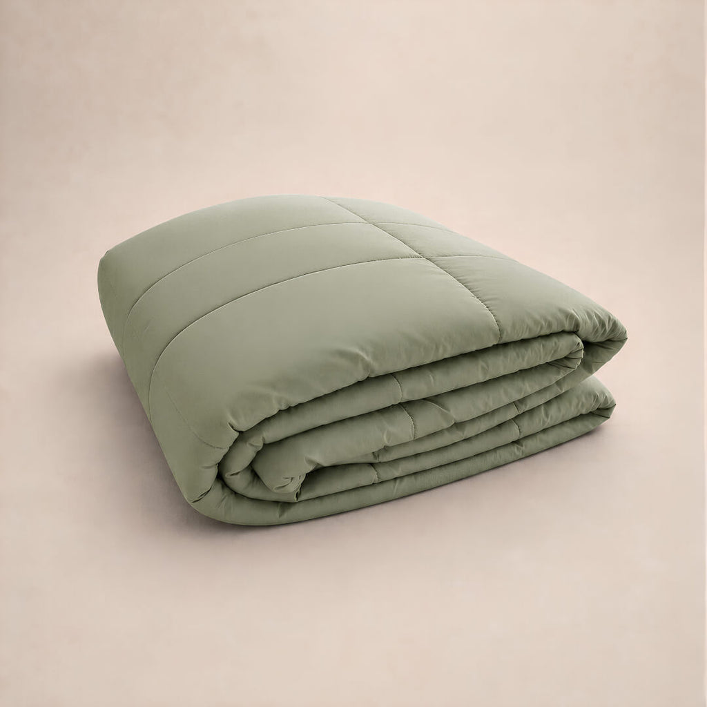Folded green cooling blanket on a beige background.