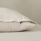 Close-up of a beige pillowcase featuring a concealed zipper closure, highlighting the secure fastening detail and soft, warm-toned fabric texture.