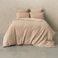 Beige textured bedding set on a bed against a plain wall.