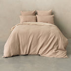 Beige textured bedding set on a bed against a plain wall.