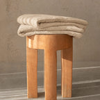 Beige bath towel folded on stool