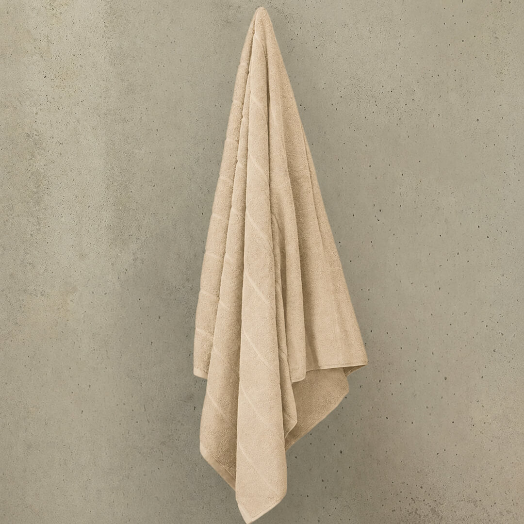 Beige bath towel hanged on wall