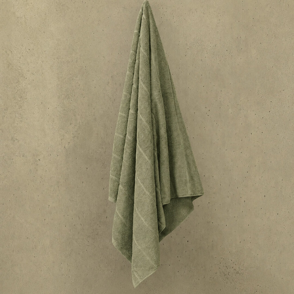 Sage bath towel hanged in wall