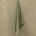 Sage bath towel hanged in wall