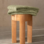 Sage bath towel folded on stool