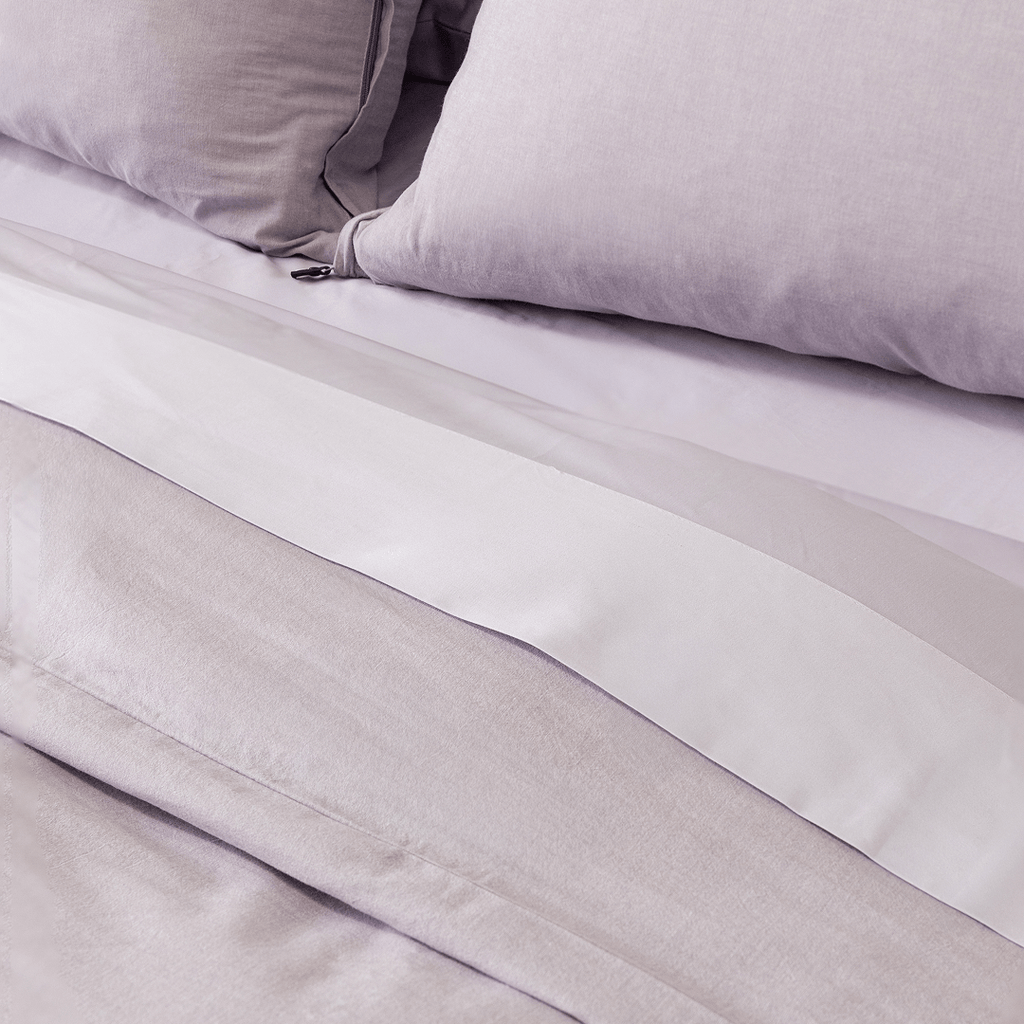 Close-up of the Daylesford quilt cover folded back to reveal crisp white sheets beneath, framed by matching Daylesford pillowcases. The layered bedding highlights the soft texture, breathable fabric, and relaxed, understated design.