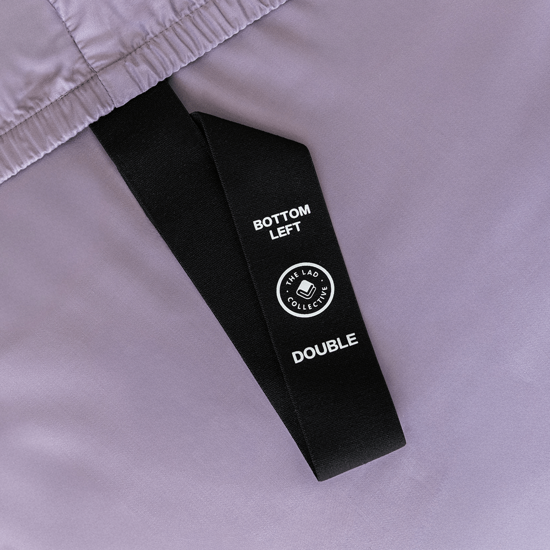 Close-up of the fitted sheet's labeled corner strap marked "Bottom Left" for quick and easy bed-making.