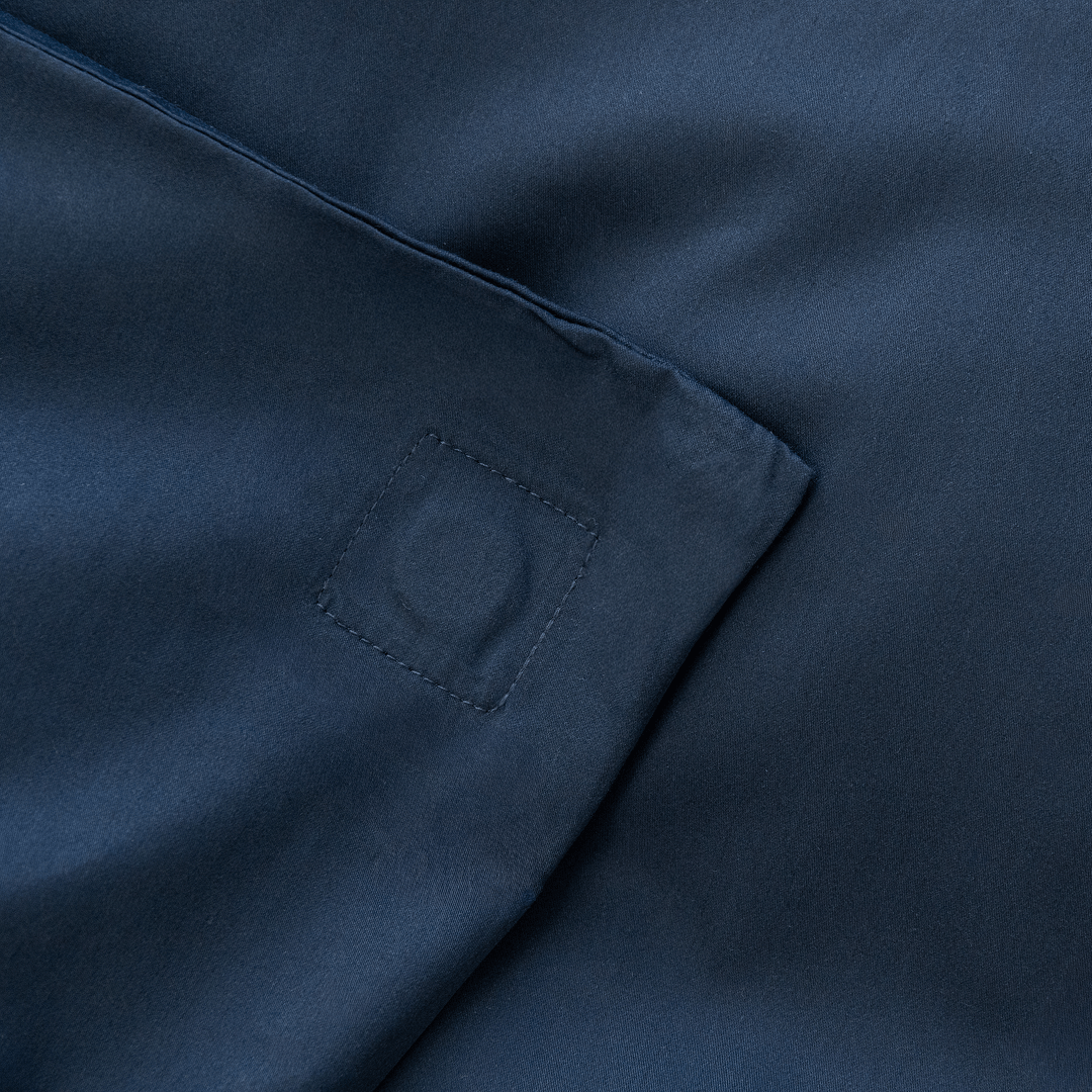 Close-up corner view of navy blue fabric showing square-stitched corner reinforcement detail