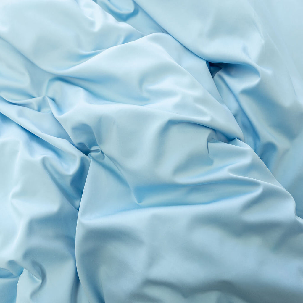 Pastel blue quilt cover set material close up.