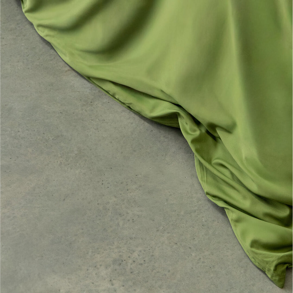 Green fabric draped over a gray surface.