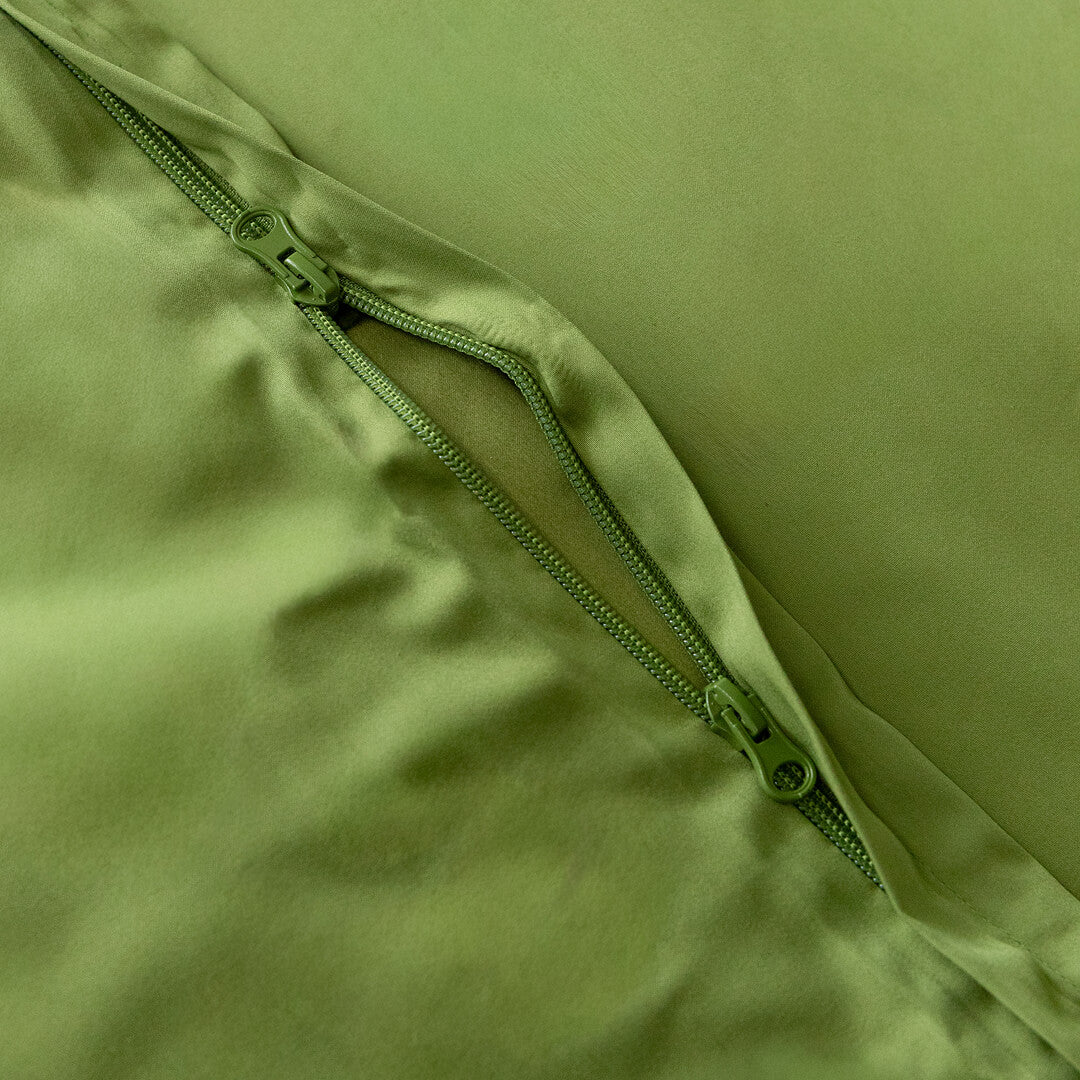 Close-up of a green zipper on a green fabric background.