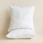 Two white European pillows on a beige background.