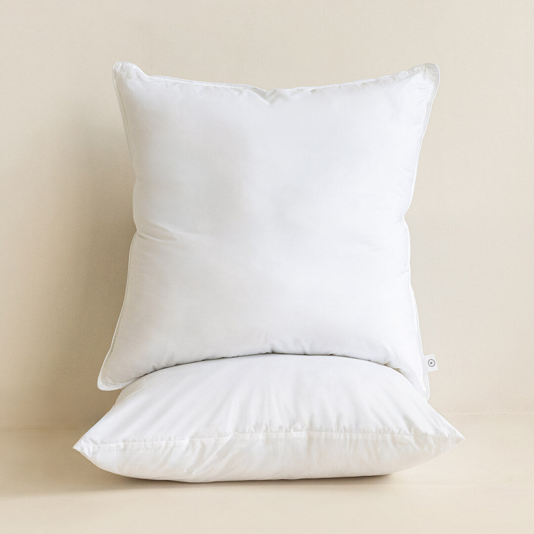 Two white European pillows on a beige background.