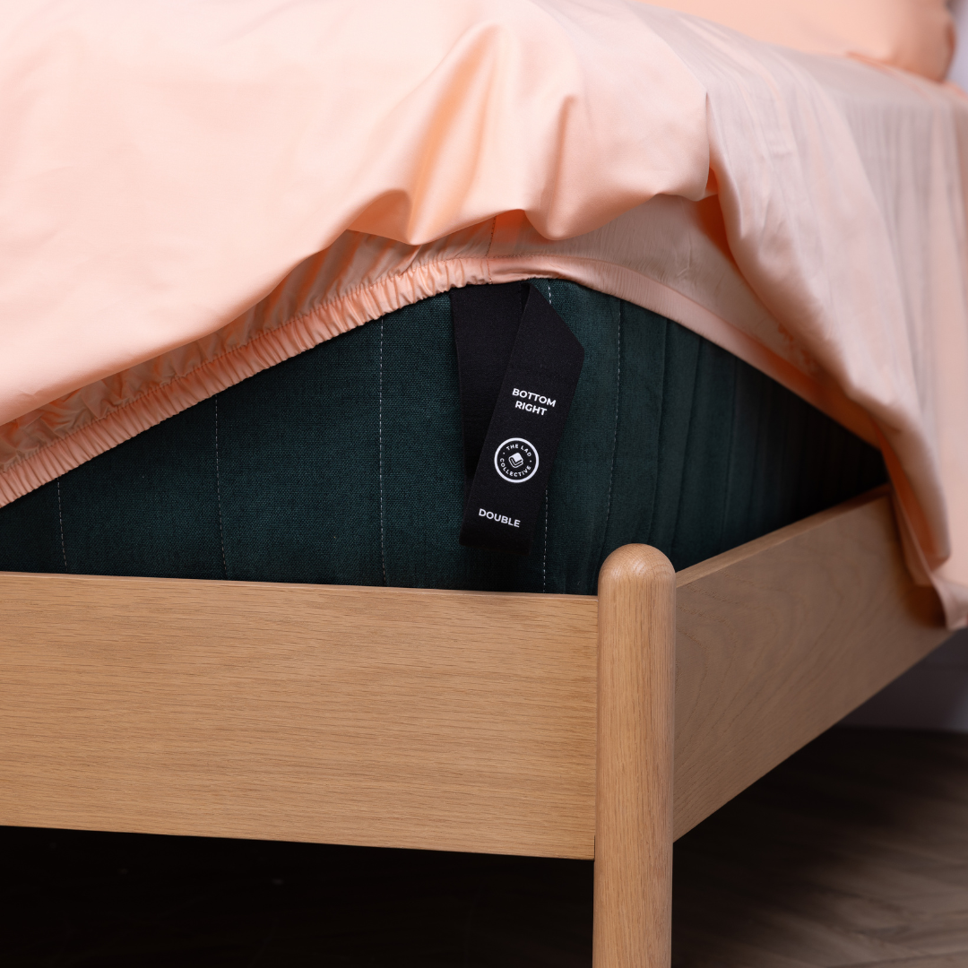 Close-up of The Lad Collective fitted sheet corner label showing 'Bottom Right' and 'Double' – innovative corner tags designed for hassle-free bed making and perfect sheet placement.