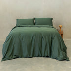 Dark green quilt cover set on a bed.