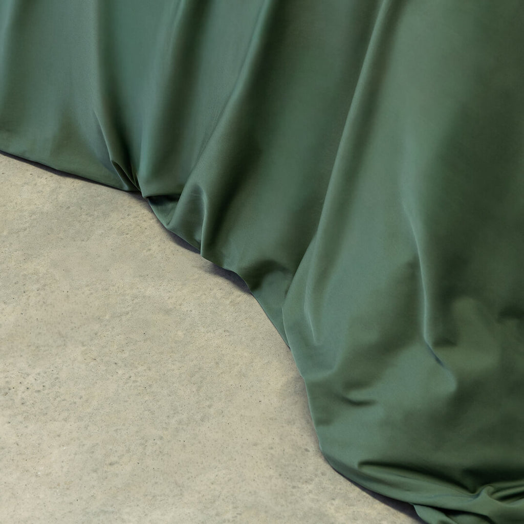 Green fabric draped over a concrete surface.