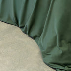 Green fabric draped over a concrete surface.