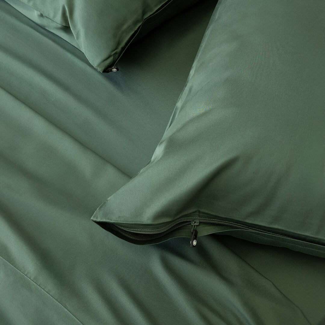 Dark green invisible zip pillowcases on the bed.