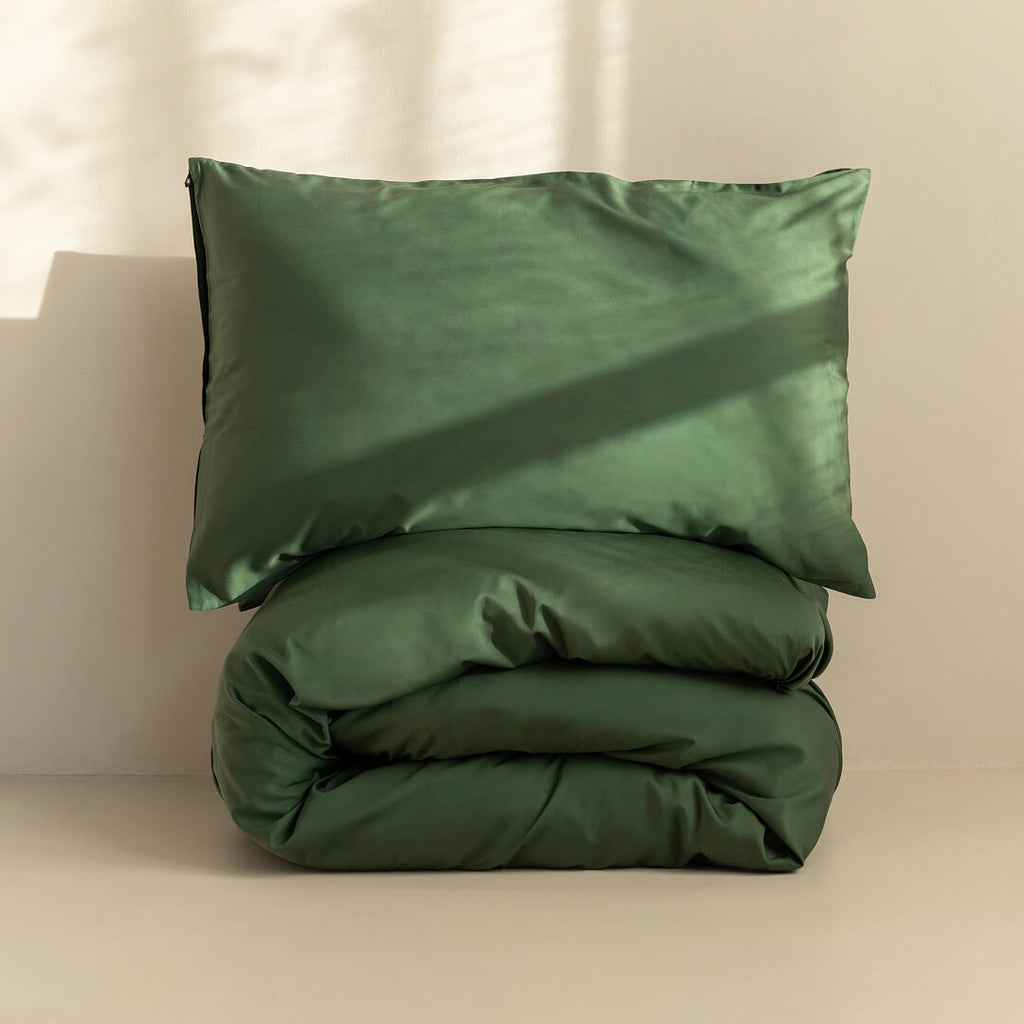 Green pillowcase and duvet set on a beige background.