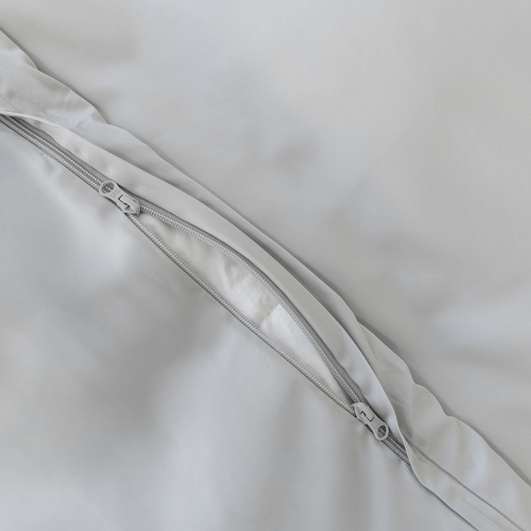 Close-up of a concealed zipper opening on a gray quilt cover, showing the matching zipper and neat stitched finish.