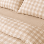 Detailed view of the quilt cover folded back to reveal the matching fitted sheet and pillowcases, showcasing the coordinated neutral bedding set.