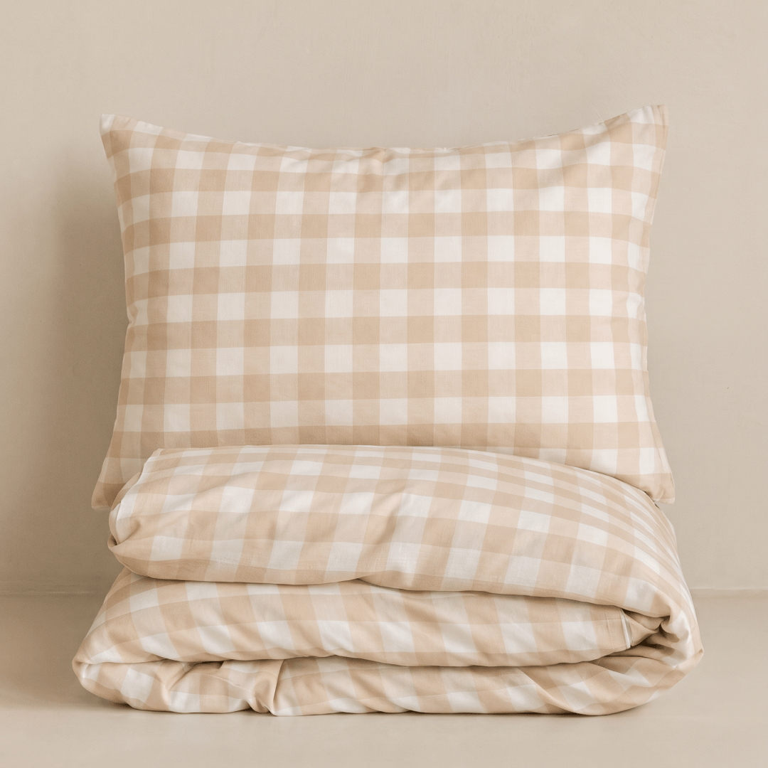 Folded beige gingham quilt cover set with a matching pillowcase, showcasing the classic checkered pattern, soft fabric, and coordinated neutral design.