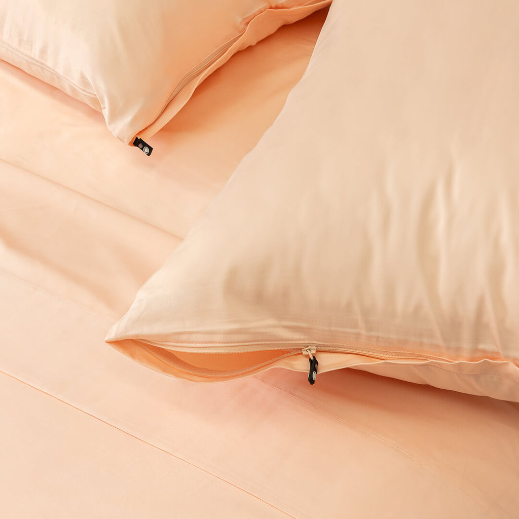 Close-up of peach-colored pillows on a matching fabric background