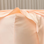 Close-up of peach-colored fabric with a neutral background.
